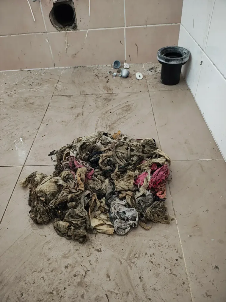 Hromada vlhčených ubrousků vytažených z ucpané stoupačky na dlažbě